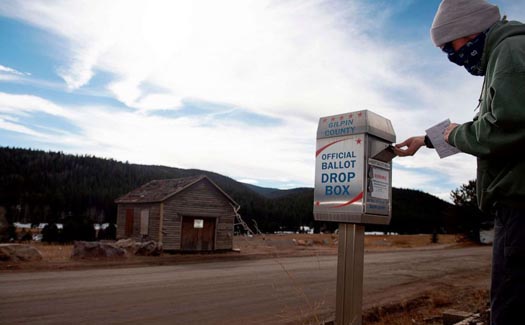 U.S. voters casts his ballot by dropping it off in a ballot vote box